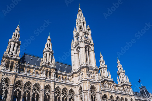 View from park on a tower and facade of Vienna City Hall in Vienna city, capital of Austria