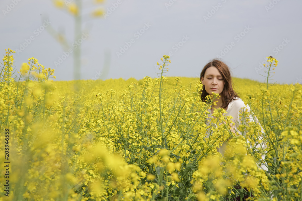 Portrait of fashionable young woman in the yellow flowers field
Portrait of fashionable young woman in the yellow flowers field