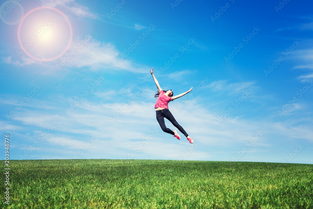 pretty young woman jumping on green grass pretty young woman jumping on green grass