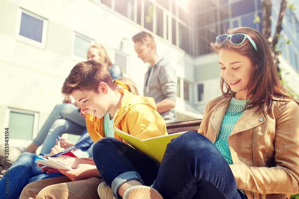 education, high school and people concept - group of happy teenage students with notebooks learning at campus yard education, high school and people concept - group of happy teenage students with notebooks learning at campus yard
