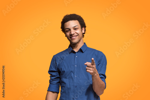 The happy business man point you and want you, half length closeup portrait on orange background. photo