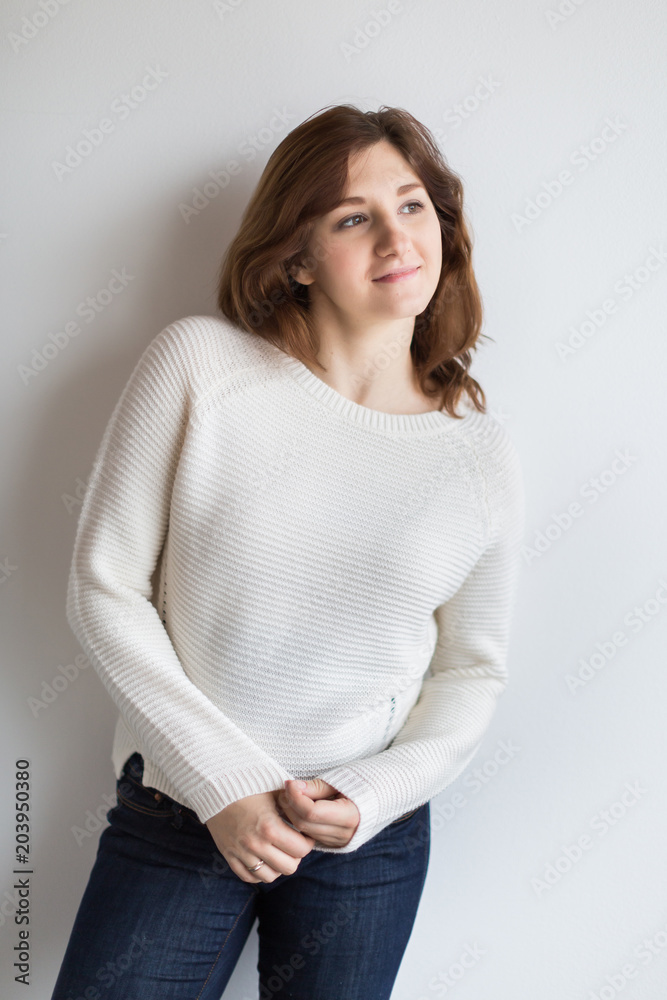 pregnancy, beauty, fashion concept. on the background of light wall there is a pretty woman with pale complexion and not very long hairs of chestnut colour pregnancy, beauty, fashion concept. on the background of light wall there is a pretty woman with pale complexion and not very long hairs of chestnut colour