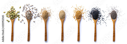 Set of spoons with different seeds on white background