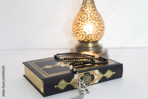 Three months.Islamic Holy Book Quran with rosary beads under soft light on White Background. Ramadan concept .