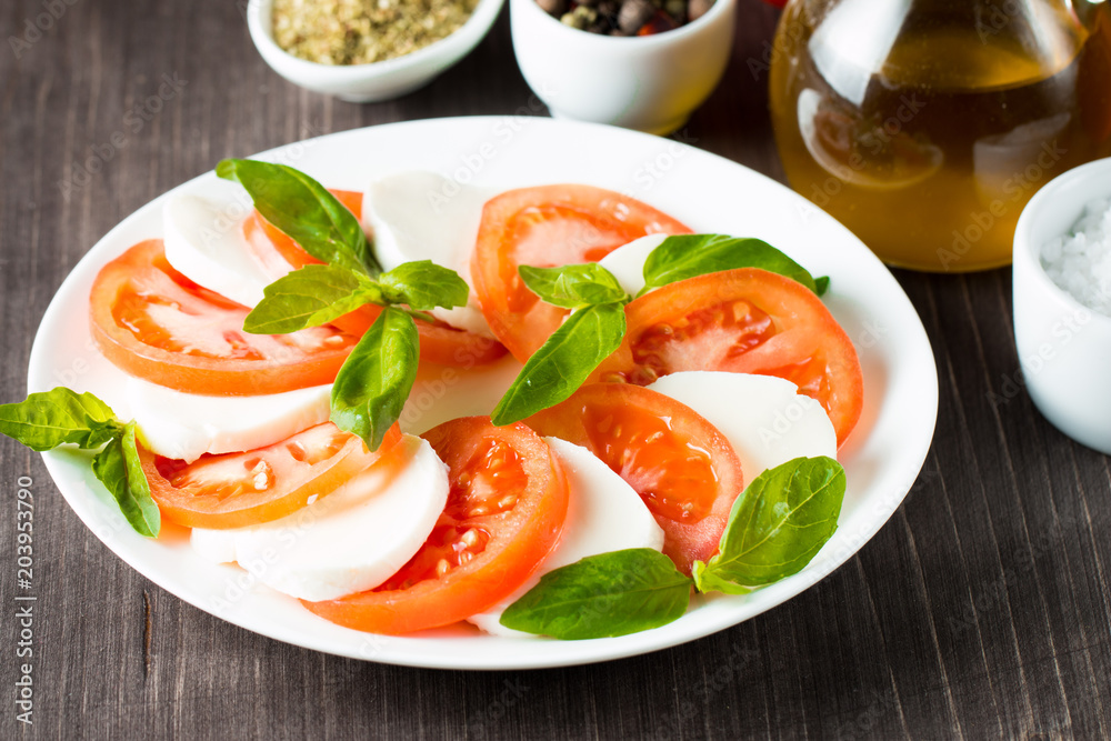 Close-up photo of caprese salad with ripe tomatoes, basil, buffalo mozzarella cheese. Italian and Mediterranean food concept. Fresh and healthy organic meal. Starter and antipasti. Close-up photo of caprese salad with ripe tomatoes, basil, buffalo mozzarella cheese. Italian and Mediterranean food concept. Fresh and healthy organic meal. Starter and antipasti.