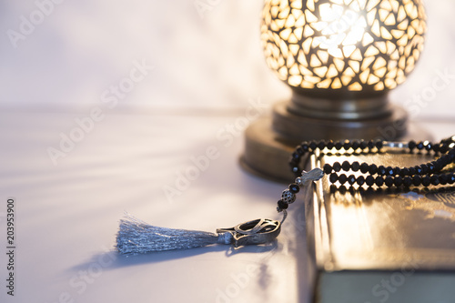 Three months.Islamic Holy Book Quran with rosary beads under soft light on White Background. Ramadan concept .