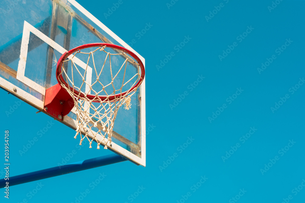 Basketball backboard with ring and hoops on outdoor court