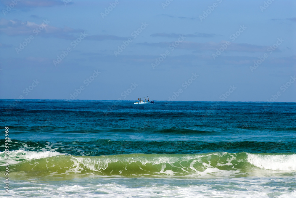 Sea view with surf and distant boat