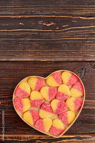 Valentines Day background with colorful candies. Jelly candies covered with sugar crystals in heart-shaped box, copy space.