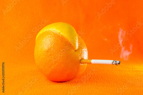 Grapefruit mutant smoking a cigarette on an orange background.