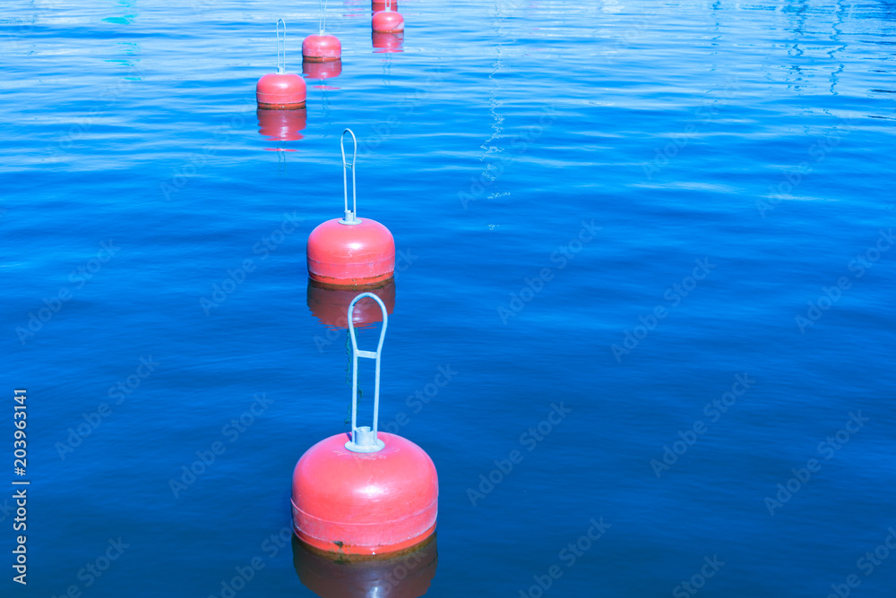 Group of red buoys on a sea surface Group of red buoys on a sea surface