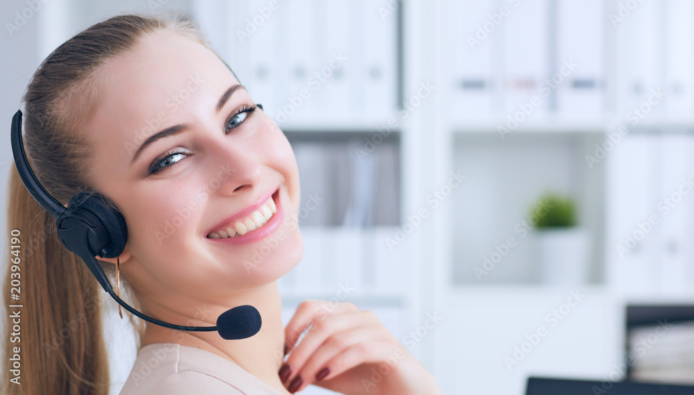 Portrait of happy smiling female customer support phone operator at workplace.