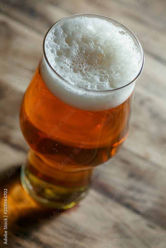 Glass of light beer on a wooden barrel Glass of light beer on a wooden barrel