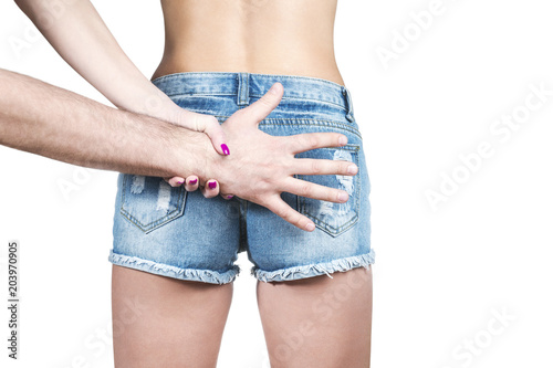 Female hand trying to stop a male hand that wants to grab an ass, isolated on a white background
