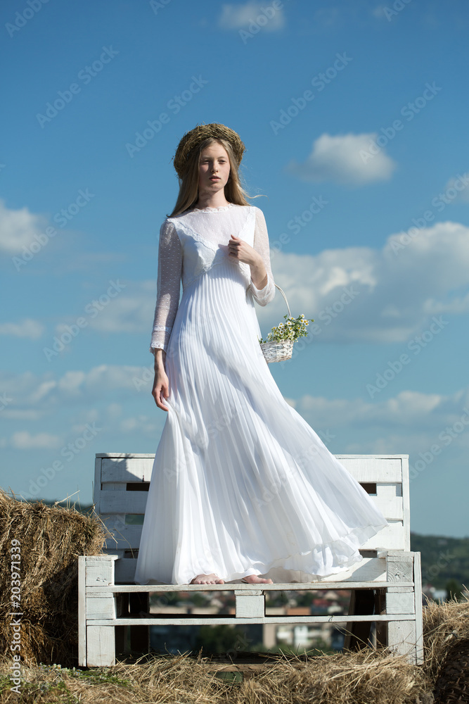 Sexy girl or woman with pretty face and flower wreath on long hair in  wedding dress holding basket with bouquet Stock Photo | Adobe Stock