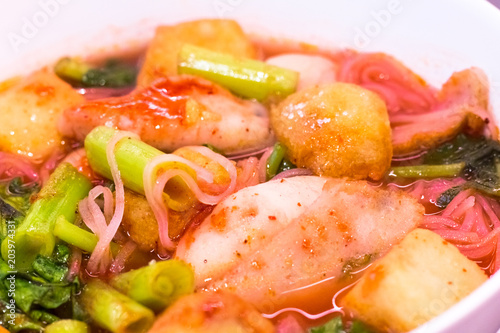Thai food.Pink seafood flat noodles.Spicy lemongrass flavored soup with pork, chicken on white background.Close up