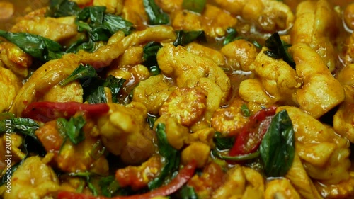 zoom out of  stir fried chicken with spicy curry paste , sweet basil, bell pepper, long yard beans , sliced corn in blue dish