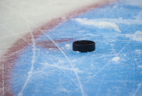 Canvas Print Black hockey puck on ice rink