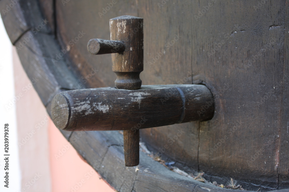 vintage brass faucet in an old oak barrel isolated