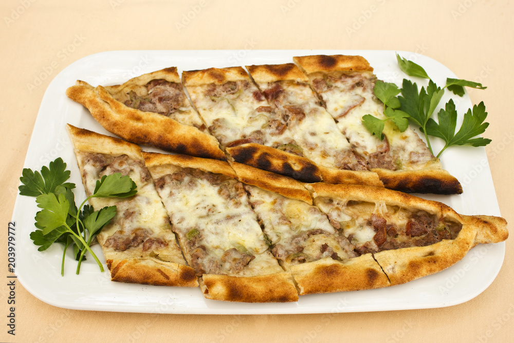 Turkish tortilla pita with pieces of meat, melted cheese and slices of vegetables Turkish tortilla pita with pieces of meat, melted cheese and slices of vegetables