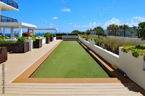Inviting upscale bocce ball court with artificial turf, on a rooftop terrace.