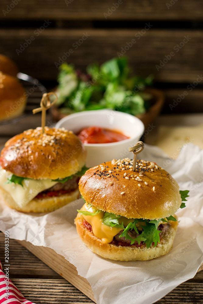 Mini cheeseburgers sliders with ground beef, cheddar, lettuce and tomato sauce Mini cheeseburgers sliders with ground beef, cheddar, lettuce and tomato sauce