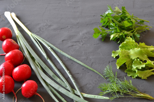 Fresh vegetables for salad on a dark background.