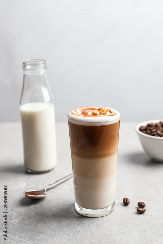 Glass with delicious caramel latte on table Glass with delicious caramel latte on table