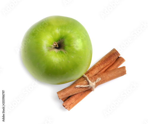 Fresh apple and cinnamon sticks on white background