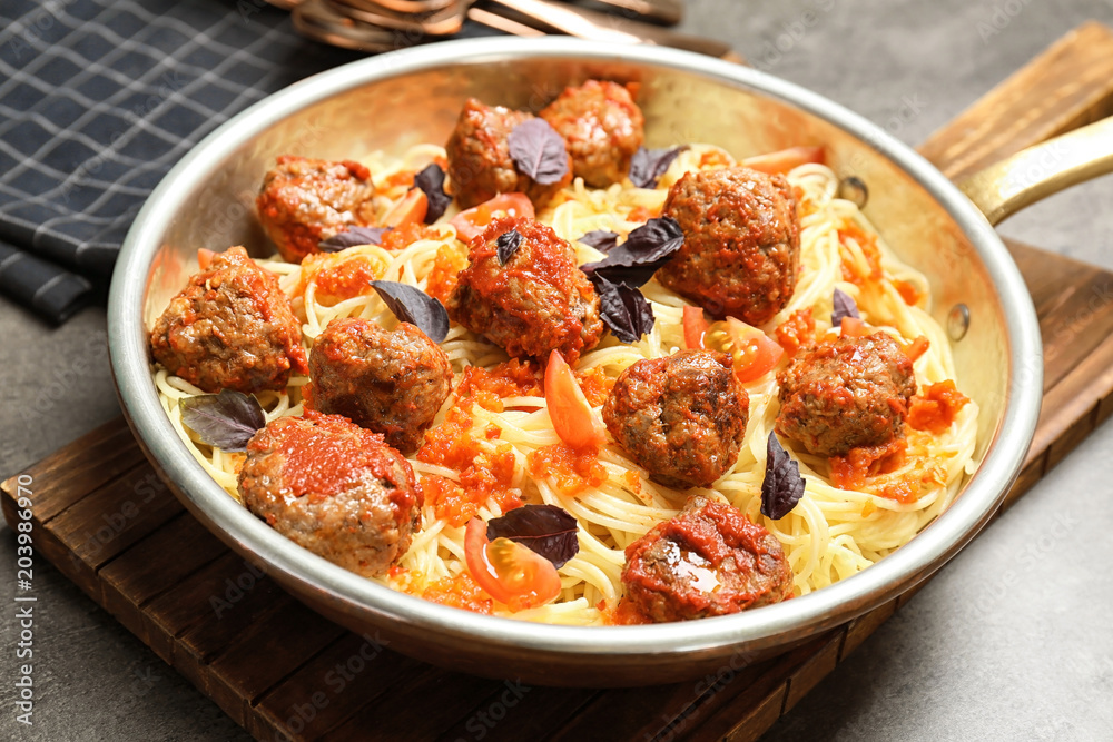 Delicious pasta with meatballs and tomato sauce in frying pan Delicious pasta with meatballs and tomato sauce in frying pan