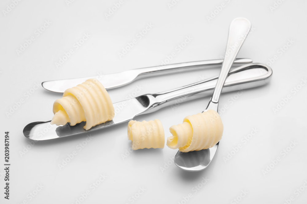 Wooden spoon with butter curl on white background Wooden spoon with butter curl on white background