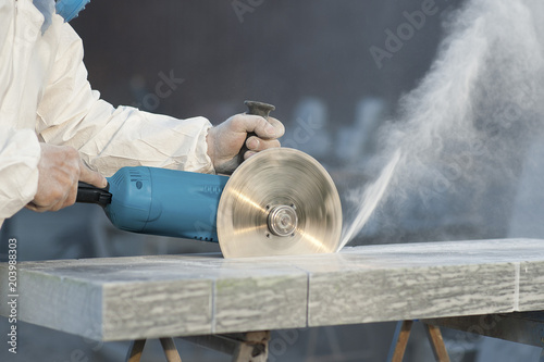 Worker cuts stone grinding machine