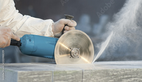 Foto Worker cuts stone grinding machine