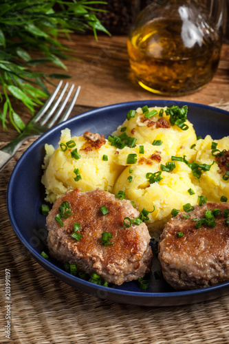 Meatballs served with boiled potatoes on a plate.