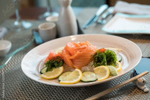 japanese food, salmon flower with cucumber and lemon slices on ice dish. sushi concept