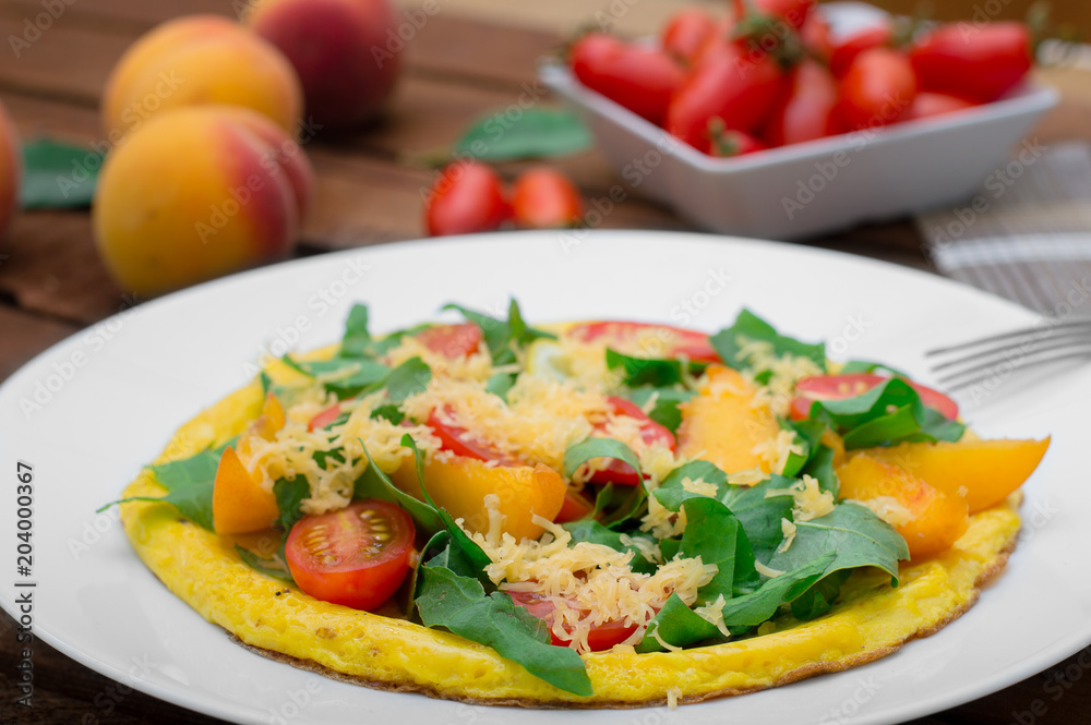 Frittata with peach, vegetables and cheese in a white plate on the rustic wooden background. Top view Frittata with peach, vegetables and cheese in a white plate on the rustic wooden background. Top view