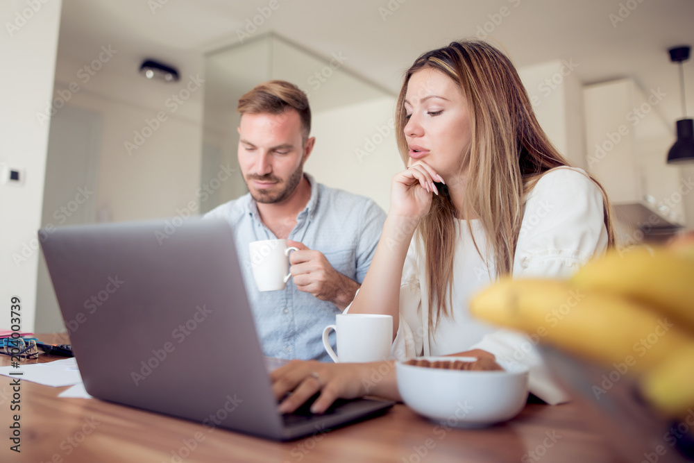 Couple paying bills online at home