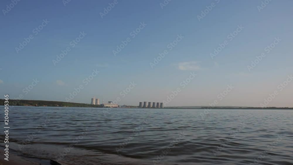 Cooling tower of nuclear power plant at cooling water lake in sunny day without steam Cooling tower of nuclear power plant at cooling water lake in sunny day without steam