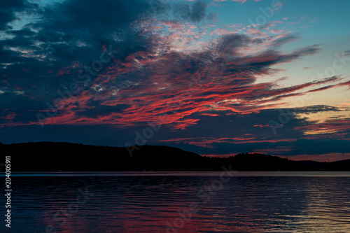 Sunset over lake - beautiful clouds in the sky and reflection on the water