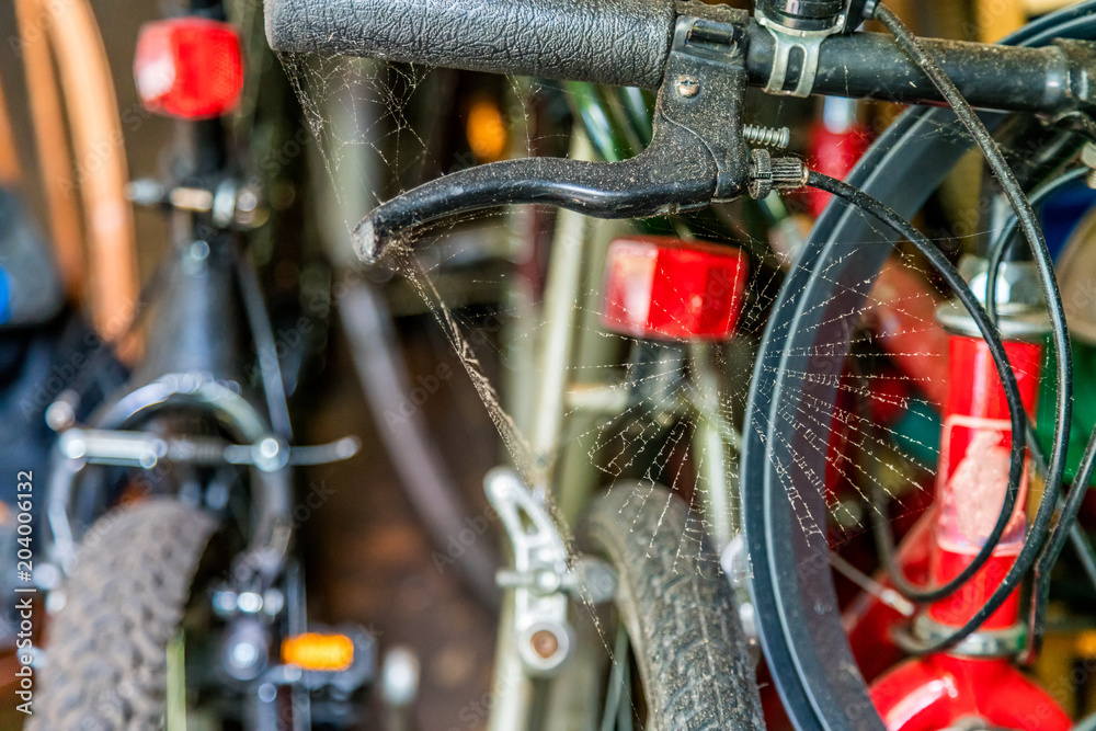 Bicycle handle with dusty spider web in a garage Bicycle handle with dusty spider web in a garage