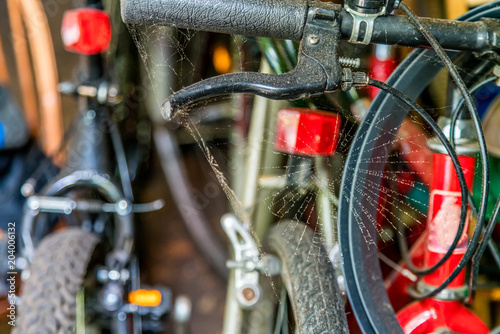 Bicycle handle with dusty spider web in a garage