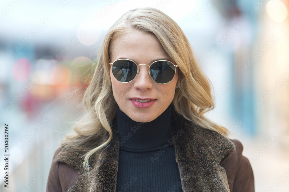 Close-up full face portrait of a beautiful blonde woman in sunglasses