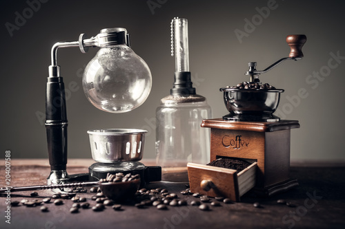 Japanese siphon coffee maker and coffee grinder on old kitchen table