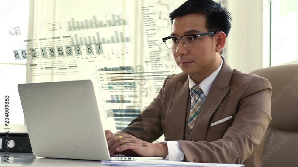An Asian businessman Working on a laptop looking intense and seriousness about the company’s sales figures performance An Asian businessman Working on a laptop looking intense and seriousness about the company’s sales figures performance