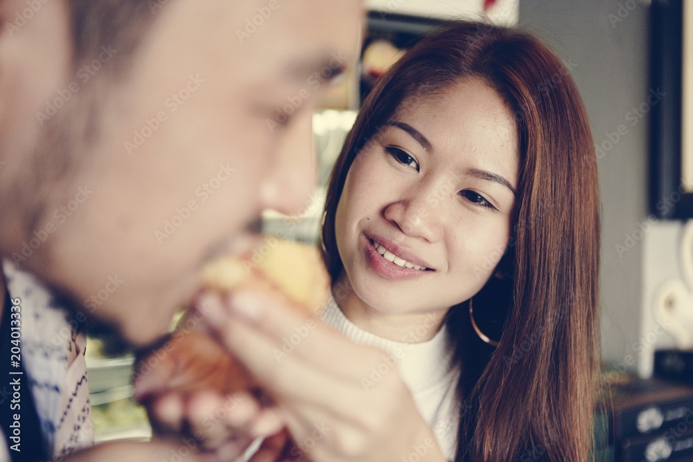 Asian girl feeding her boyfriend Asian girl feeding her boyfriend
