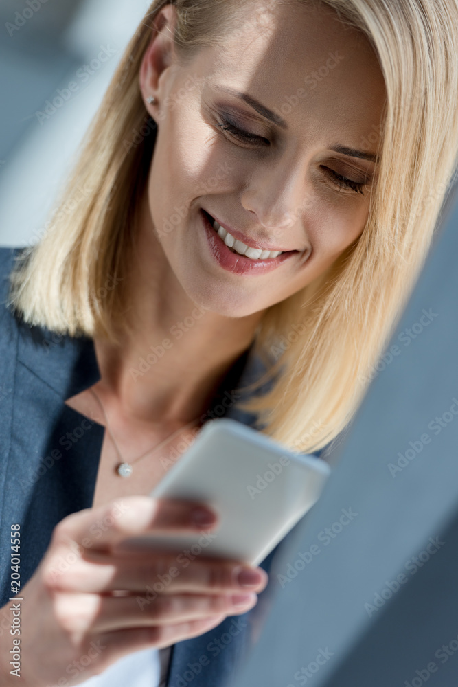 beautiful smiling businesswoman using smartphone, close-up view