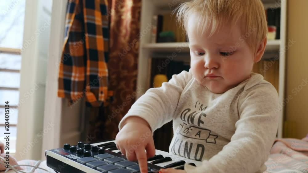 one year old excited baby boy using akai mpk mini device young male musician developing musical talent portrait at home sweet innocence playing playful cheerful child