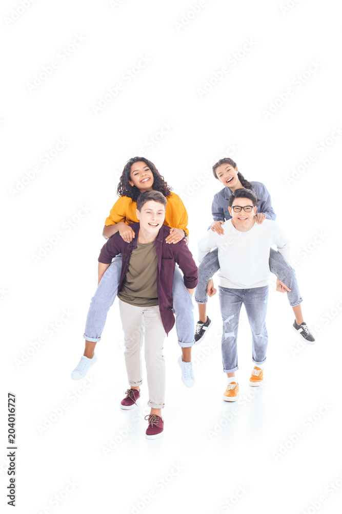 happy interracial teen friends piggybacking together isolated on white happy interracial teen friends piggybacking together isolated on white