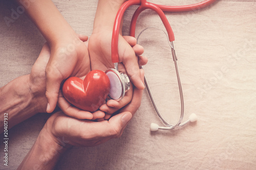 child and adult holding red heart with stethoscope, heart health,  health insurance concept, world heart day, world health day, world hypertension day, health insurance photo