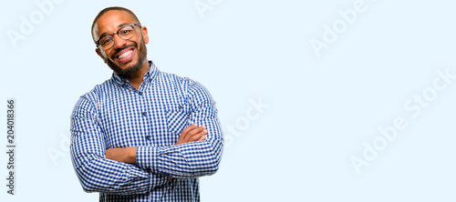 African american man with beard with crossed arms confident and happy with a big natural smile laughing isolated over blue background